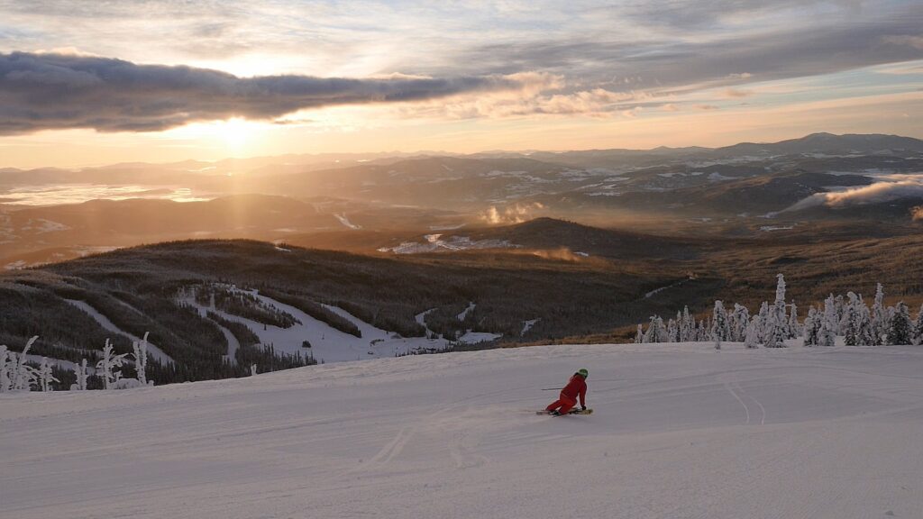 Photo of a skier on Mt Baldy with a sunset in the distance